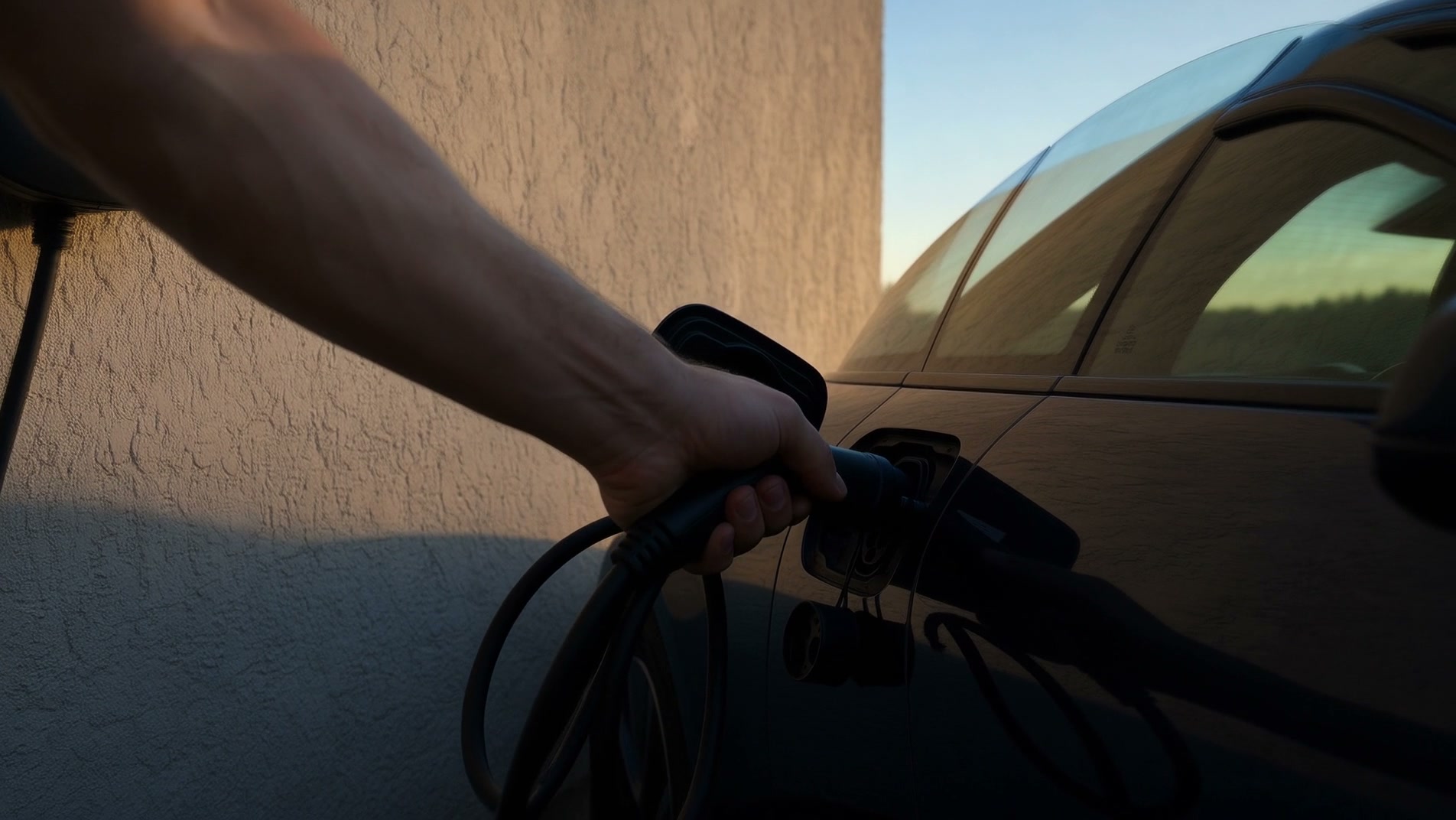 Ladekabel an einer Wallbox neben einem Elektroauto